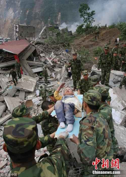 2008年5月13日,3岁的郎铮躺在担架上向解放军战士敬礼。杨卫华 摄 图片来源:视觉中国 汶川地震十二年:遥忆悲伤,记住灾难中不屈的精神